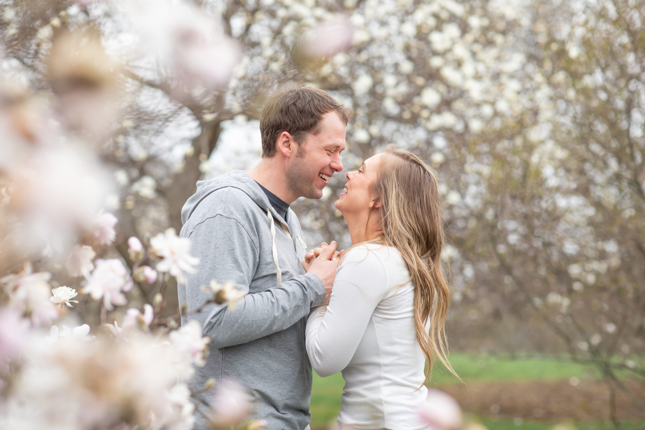 Engaged couple nuzzled together at UW Madison Arboretum