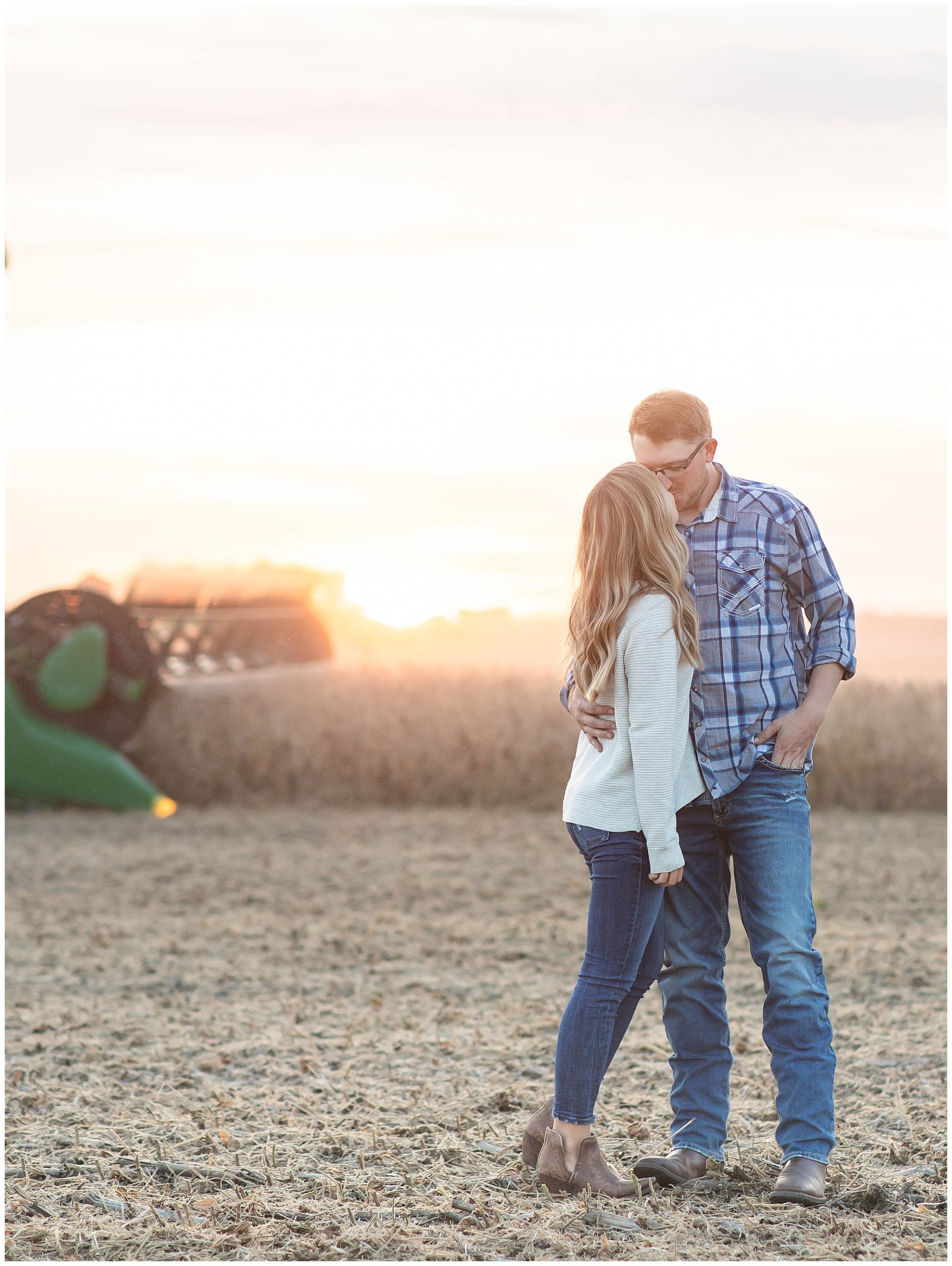sunset engagement session by combine in field 